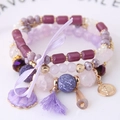 Mehrlagiges lila Boho-Perlenarmband mit Muschel-, Quasten- und Schleifenanhänger - Lila