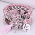 Bohemian meerlaagse kralenarmbandenset met roze kwastjes en bedeltje op witte achtergrond - Roze