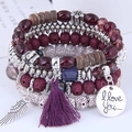 Detail eines böhmischen mehrlagigen Perlenarmbands mit lila Quaste und Flügelanhängern - Lila