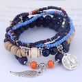 Dettaglio del bracciale boho multistrato con ciondolo Torre Eiffel e perle di legno - Blu