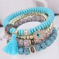 Bohemian multilayer beaded bracelet with Hamsa charm and blue tassel on display - Blue