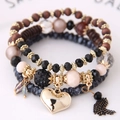 Nahaufnahme eines Boho-Perlenarmband-Sets mit Herzanhänger und schwarzer Quaste - Schwarz