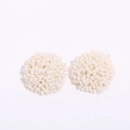 Detailed view of handmade bohemian white seed bead stud earrings in a hemispherical shape - Beige
