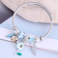 Silbernes Charm-Armband mit Sonnenblumen- und Federanhängern auf Stahldrahtband - Blau