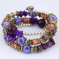 Dettaglio di bracciale multistrato boho con perline viola, oro e cristalli sfaccettati - Viola