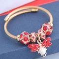 Bracciale rigido bohémien in filo d'oro con ciondolo ape e perle rosse su scatola - Rosso