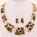 Set di gioielli con collana e orecchini leopardati mostrati su un busto bianco - Set Collana + Orecchini / Stampa leopardata