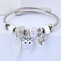 Silver stainless steel bead bracelet featuring lavender owl and white angel wing charms - Purple