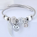 Silver stainless steel cable bangle with owl, feather charms and zircon accents - Gray