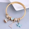 Golden cable bracelet with blue enamel starfish and shell charms in summer ocean style - Blue