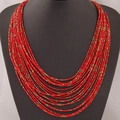 Collier bohème multicouches en perles rouges avec accents dorés sur présentoir - Rouge