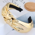 Elegante cerchietto per capelli in metallo dorato intrecciato su supporto bianco - Oro