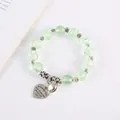 Dettaglio del bracciale con perline verde chiaro e ciondoli a forma di cuore - Verde