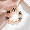 Detailopname kralenarmband met gouden ringen, zwarte stenen en amberkleurige kristallen - Zwart