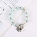 Dettaglio del bracciale con perline di cristallo azzurro e ciondoli a foglia e cuore - Blu Lago