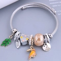 Pulsera ajustable de alambre de acero inoxidable con dijes de pájaro y hoja vista 45° - café