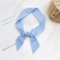 Bandeau à nœud vichy bleu clair sur fond esthétique de tulle et osier tissé - Carreaux Bleus