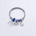 Detail van staaldraad armband met blauwe kralen en levensboom en olifant hangers - Koningsblauw