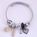 Silver bead charm bracelet with twisted cable band featuring pearls and sparkling heart pendants - Black