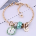 Golden snake chain bracelet with sunflower charm and cute lion pendant on white background - Green