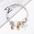Beaded charm bracelet with dragonfly, heart, and floral pendants on a silver twisted wire band - White