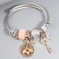 Adjustable steel wire bracelet featuring bee, key, and pink heart charms in silver finish - Pink