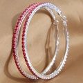 Orecchini a cerchio in argento con strass rossi su sfondo di seta dorata - Base Argento Rosso