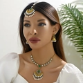 Ethnic gold jewelry set with green gemstones and white pearls on a female model - Green