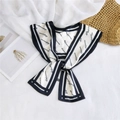 Detailed view of an elegant cream silk scarf tied in a bow with black floral lettering - Beige Black Letter Print Style (23)