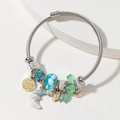 Zilveren gedraaide armband met blauwe kristallen, maanbedel en gegraveerde hangers - Blauw