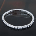 Close-up of a silver tennis bracelet with sparkling round crystals on a black surface - 1-Row Style (09052701)