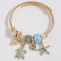 Bracelet doré thème océan avec breloques tortue, étoile de mer et coquillage sur fil torsadé - Bleu