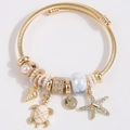 Bracelet jonc perlé doré avec breloques océaniques, tortue, étoile de mer et perles - Blanc