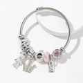 Pink bear and crown charms on silver twisted cable stainless steel bangle bracelet - Pink