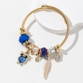 Gouden geweven open armband met uil- en veerhangers en blauwe kralen - Blauw