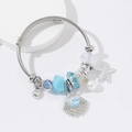 Silver cable charm bracelet with blue beads, starfish, shell, and heart pendants - Blue