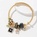 Gouden gedraaide armband met hart- en beerbedeltjes, zwart emaille en imitatieparels - Zwart
