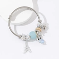 Silver stainless steel charm bracelet with owl, Eiffel Tower, and faux pearl charms - Blue
