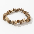 Detailed macro shot of natural irregular wood grain jasper stone beads on an elastic bracelet - Tan