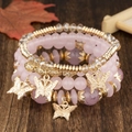 Détail macro du lot de 4 bracelets en perles roses avec breloques papillon dorées - Rose