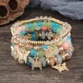 Détail d'un lot de 4 bracelets bohèmes multicouches avec breloques papillon dorées - Multicolore Clair