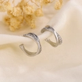 Elegante zilveren zirkoon ear cuffs met kruisontwerp op beige linnen stof gepresenteerd - Zilveren Kruis Ingelegde Zirkonia Stijl (A131)