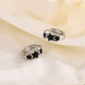 Silver hoop earrings featuring three black star motifs on a textured linen background - Black Star Style (HL-69)