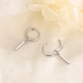 Orecchini a cerchio in argento S925 con barra geometrica su sfondo di lino rustico - Argento