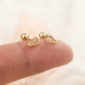 Minimalistische gouden vleugel oorknopjes met schroefsluiting getoond op een vinger - Goud (c155)