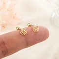 Elegant gold hollow rose stud earrings with screw ball back closure on fingertip - Hollow Rose (C162) / Gold