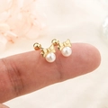 Elegant gold bow earrings with white pearls and secure screw back held on fingertips - Gold (C166)