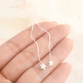 Macro detail of S925 silver wave tassel earrings with delicate floral pendants - Flower Wave Threader Earrings (A83) / Silver