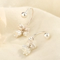 Orecchini a giglio d'argento con fiocco e nappe floreali su sfondo di lino beige - Stile Fiocco Mughetto Argento (C200)