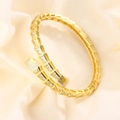 Luxurious gold snake bone bracelet with full crystal pavé setting on creamy fabric - Gold